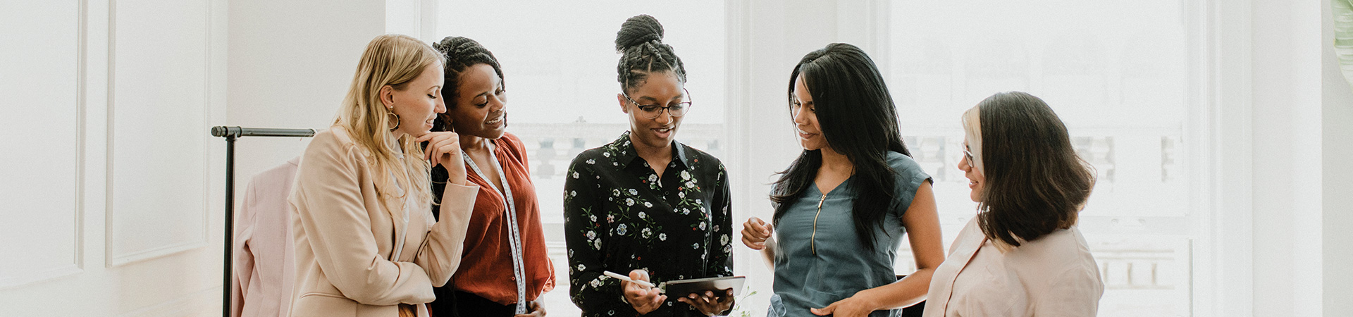  Group of professional women gathered around a tablet 