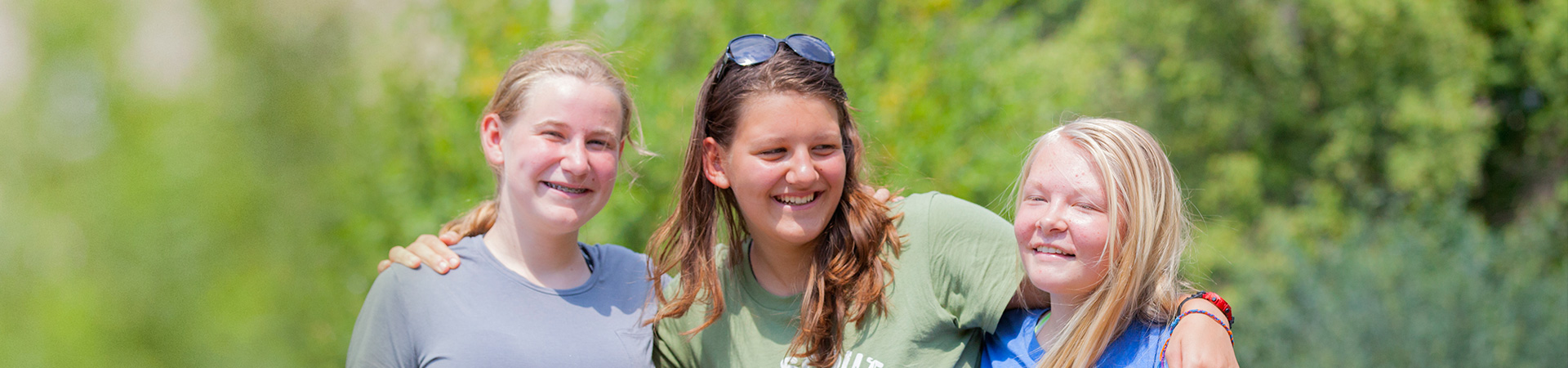  Three Senior Girl Scouts with their arms around each other smiling at the camera 