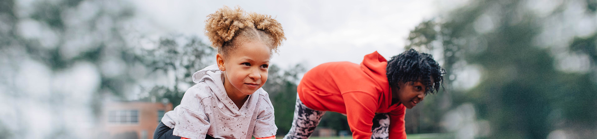 Two Daisy girls with determined expressions taking a starting position for a footrace 