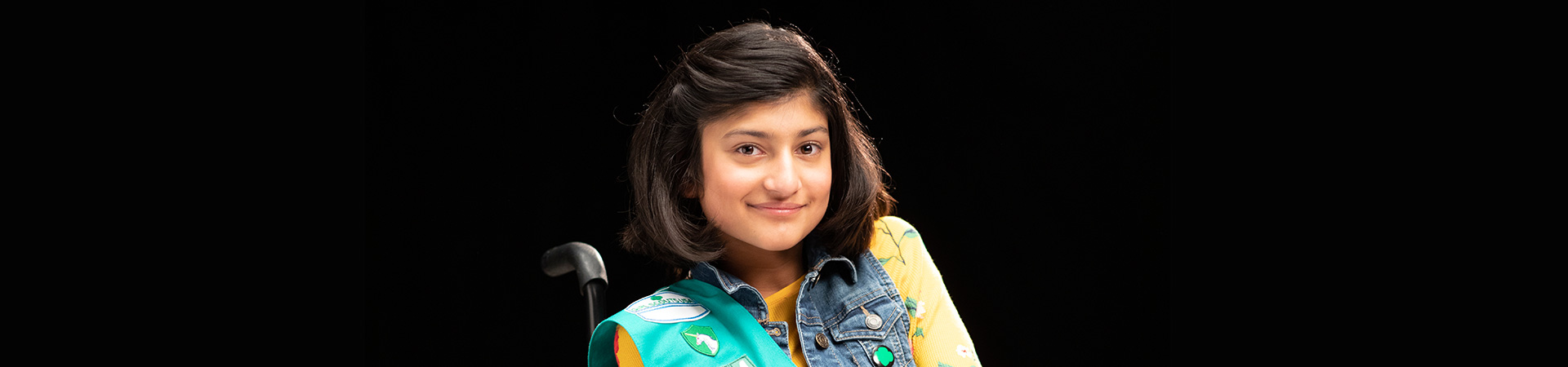  portrait of a girl in a wheelchair against a black background 